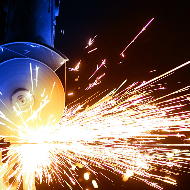 A rendering of an angle grinder ejecting sparks.